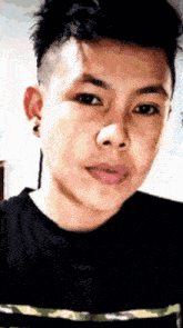 a close up of a young man 's face with a black shirt