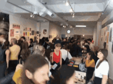a crowd of people are gathered in a room with a clock on the wall that says ' a ' on it