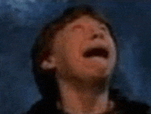 a man is crying with his mouth open in a blurry photo .