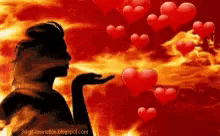 a silhouette of a woman blowing a kiss surrounded by red hearts