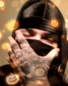 a person wearing a black mask and gloves with pumpkins around them