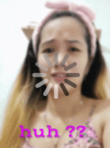 a woman wearing a pink headband has a loading screen behind her