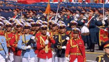 a group of soldiers marching in a parade with a drummer playing a drum