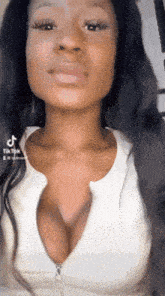 a woman is wearing a white top with a plunging neckline ..