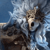 a close up of a statue of a woman with long hair and horns yawning .