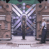 a woman is standing in front of a large metal door