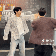 two men are dancing in front of a wall that has a van on it
