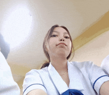 a girl taking a selfie with a white shirt and blue sleeves