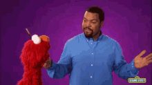 a man in a blue shirt with sesame street written on the bottom