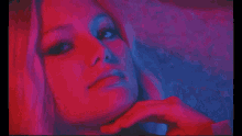 a close up of a woman 's face with red and blue light behind her