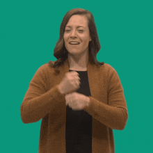 a woman in a brown cardigan is making an ok sign with her hands