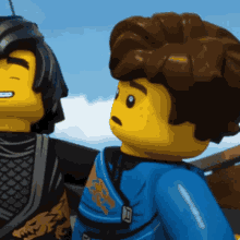 two lego figures are standing next to each other with one wearing a blue outfit with a dragon on it