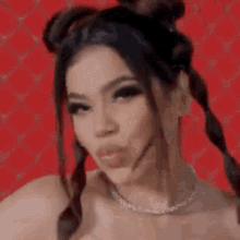 a close up of a woman with pigtails and a necklace .