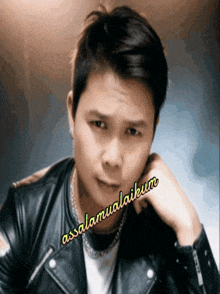 a man wearing a black leather jacket with the words assalamualaikum written on it