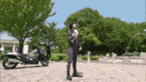 a person in a purple outfit stands in front of a motorcycle