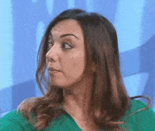 a woman in a green sweater is making a face