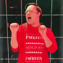 a man wearing a red shirt that says sleigh on boys on it