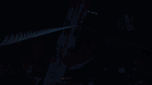 a crane is hanging from a rope in a dark room