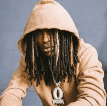 a man with dreadlocks is wearing a hoodie and a necklace with the number 0 on it .