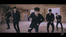 a group of young men are dancing in a room in a video .