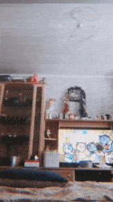 a living room with a clock on the wall and a television with cartoon cats on it