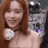 a woman with long red hair is smiling and looking at the camera while wearing headphones .