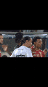 a soccer player wearing a white shirt that says le coq sportif on it