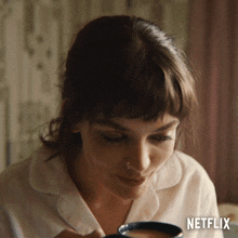 a woman drinking from a cup with netflix written on the bottom right