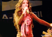 a woman singing in front of a sign that says a.