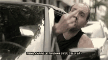 a man giving the middle finger while sitting in a car
