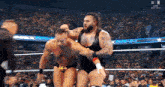 two men are wrestling in a wrestling ring while a crowd watches .