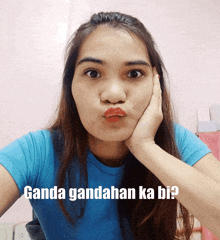 a woman in a blue shirt is making a funny face with ganda gandahan ka bi written below her