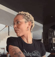 a woman wearing glasses and a t-shirt that says nilopsio on it