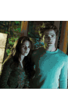 a man and a woman standing next to each other looking at the camera