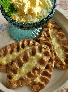 a bowl of scrambled eggs sits next to a plate of pastry