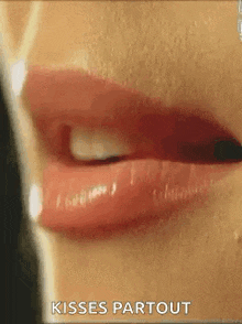 a close up of a woman 's lips with the words `` kisses partout '' written below it .