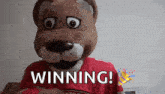 a stuffed animal mascot is wearing a red shirt and says `` winning '' .