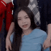 a woman in a blue shirt is standing next to a man in a red shirt .