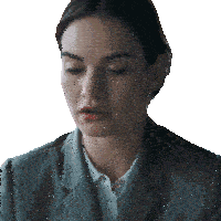 a woman in a grey suit and white shirt looks down with her eyes closed