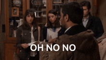 a man is sitting in front of a group of people holding a piece of paper and says oh no no .