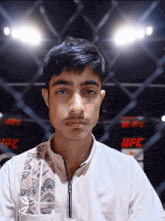 a young man stands in front of a sign that says ufc on it