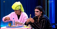 two men are sitting at a table with a tray of food and a bottle of mustard on it