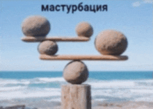 a stack of rocks balanced on a wooden post with the word masturbation written on the top