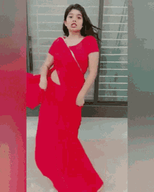 a woman in a red dress is dancing