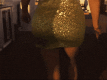 a woman in a green dress is standing in front of a table