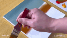 a person is holding a brush over a piece of paper that says made in animotica