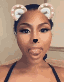 a woman wearing a snapchat filter with ears and a nose on her face .