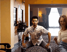 a man and a woman are squatting down in a hallway