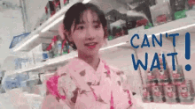 a girl in a pink kimono is standing in front of a shelf that says can 't wait !