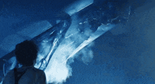 a man is standing in front of a monster that is glowing in the dark